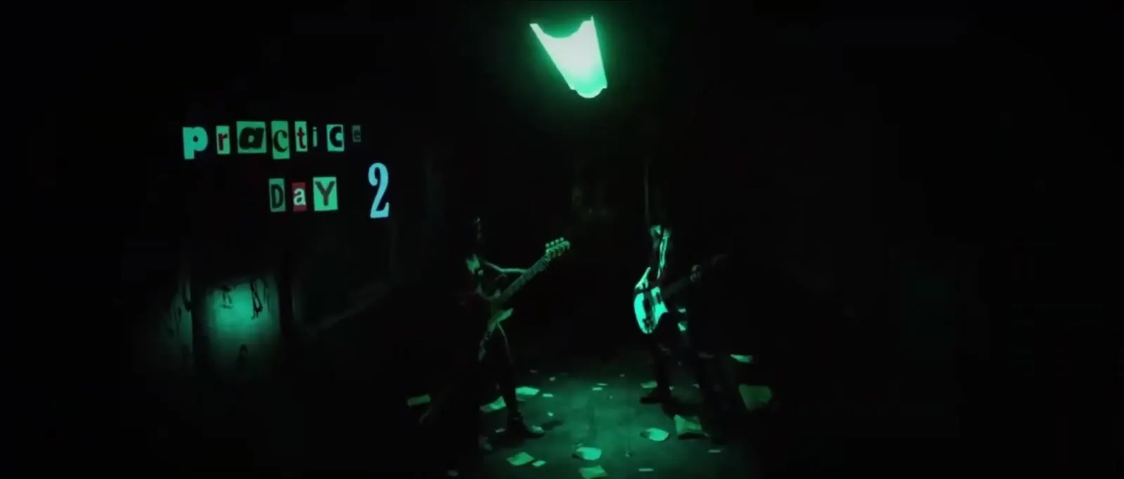 Two silhouettes under a green neon