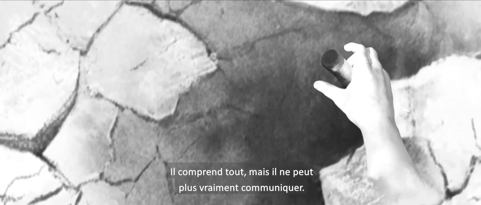 Une main sur un sol craquelé