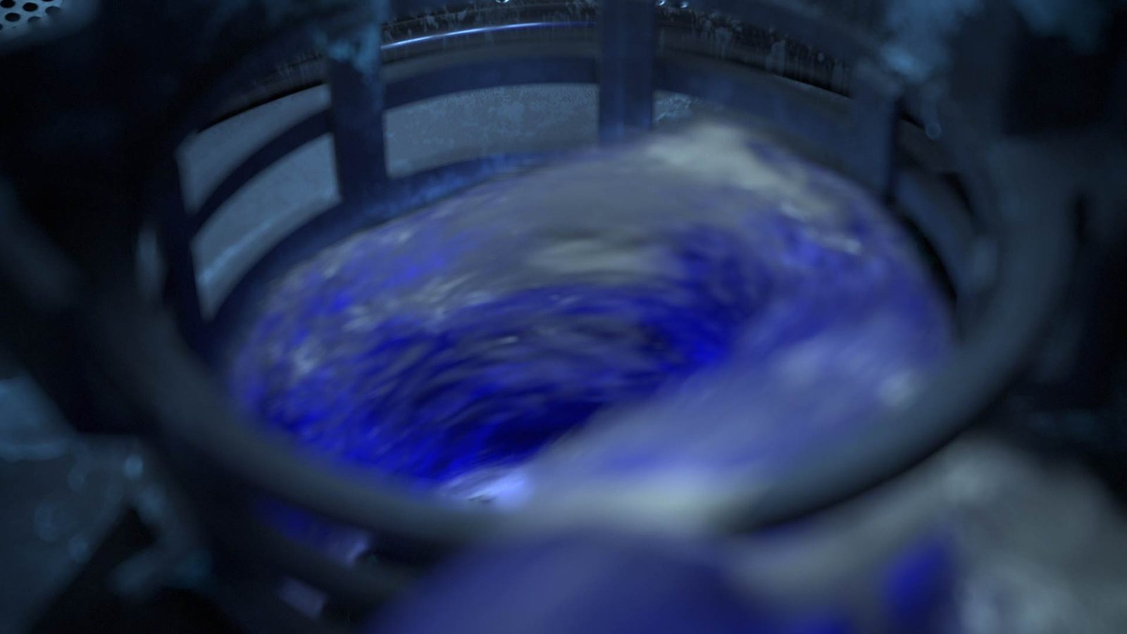 Tourbillon de liquide bleu dans le panier du lave-vaisselle