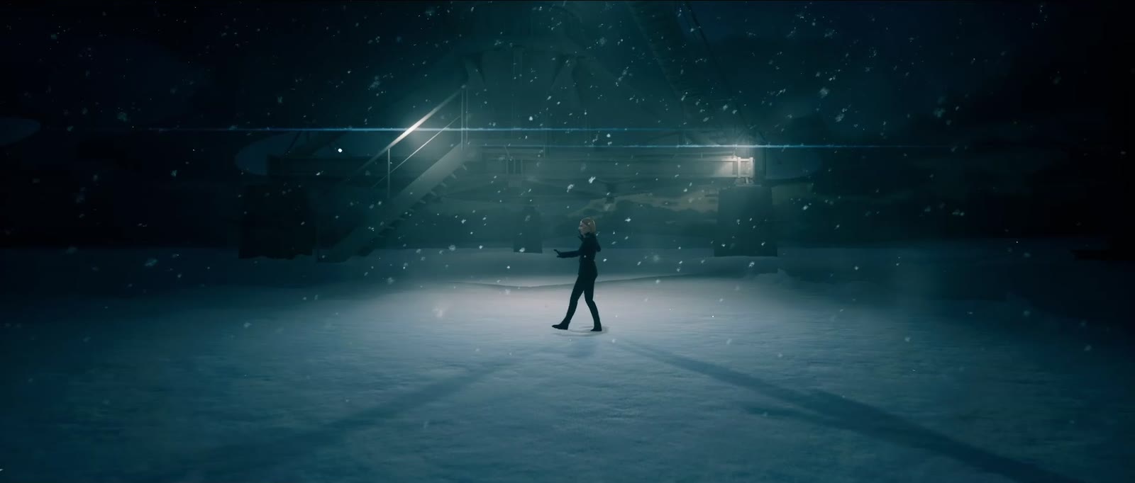 Une silhouette marche sous la neige, dans la nuit